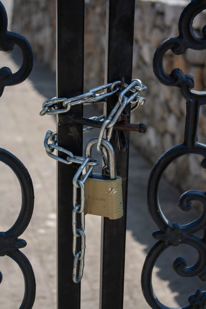 A padlock is attached to a gate with a padlock